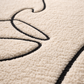 Close-up of a textured beige carpet with a black line design