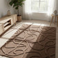 Brown patterned rug on a light wooden floor with a plant and small table in the background.