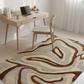 Modern home office with a wooden desk, chair, and patterned rug.
