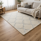Beige patterned rug on a wooden floor in a living room with a beige sofa and decorative items.