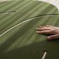 Hand touching a green textured surface