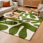 Living room with a green and white patterned rug, wooden coffee table, and beige sofa.