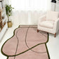 Modern living room with a pink and green abstract rug, white armchair, and bookshelf.