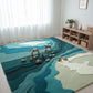 Children's playroom with a colorful rug featuring a landscape design, toys, and a bookshelf.