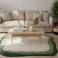 Beige sectional sofa with a wooden coffee table and decorative items in a living room setting.