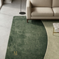 Green rug with a gold logo in a living room setting