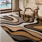 A large area rug with a wavy, organic pattern in beige, brown, black, and cream, styled in a modern living room next to a window overlooking a dock.