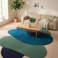 Living room with a colorful rug, beige sofa, and wooden coffee table.