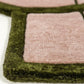 Close-up of a green and pink textured rug corner