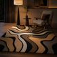 A modern area rug with a bold, abstract wavy pattern in beige, brown, black, and cream, styled in a warm, dimly lit living room next to a mid-century modern chair and a floor lamp.