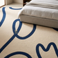 Beige carpet with blue abstract patterns in a bedroom setting