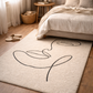 Beige rug with black abstract design in a bedroom setting