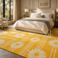 A bright yellow area rug with a white daisy and stripe pattern in a modern, sunlit bedroom setting.