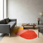 Modern living room with a gray sofa, wooden coffee table, and colorful abstract rug.