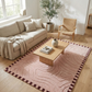 Living room with a beige sofa, wooden coffee table, and pink patterned rug.