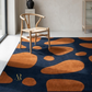 Rug with brown abstract patterns on a blue background, placed in a room with a chair.