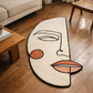 Abstract face-shaped rug on a wooden floor with a couch and coffee table in the background
