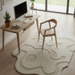 Modern home office with a desk, chair, and decorative rug.