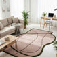 Modern living room with a pink and green rug, beige sofa, and wooden coffee table.
