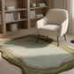 Rug with wavy design in a room with a bookshelf and chair.