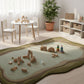 Children's playroom with a green and brown rug, toys, and a small table.