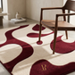 Modern room with a red and beige patterned rug and a wooden chair.