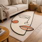 Abstract rug with geometric design on a wooden floor in a living room setting.