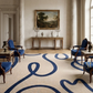 Elegant room with classical furniture, blue accents, and a large window.