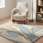 Rug with nature-themed design in a room with a chair and bookshelf.