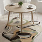 Dining room with a round wooden table and chairs on a patterned rug.