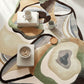 Abstract patterned rug with a coffee table and decor items on a light wood floor.