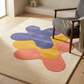 Colorful abstract rug on a wooden floor with a chair and decorative elements.