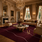 An ornate luxury living room featuring a deep burgundy area rug with white wavy lines and a gold 'Aldam Rose' monogram. The room is styled with classic cream-colored furniture, gold-trimmed chandeliers, and large drapes.