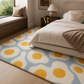A modern bedroom scene featuring a plush area rug with a light blue background and a bold yellow and white sunflower pattern, styled under a neatly made bed.
