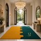 A large rectangular entryway rug in a luxurious hallway, featuring a split design of mustard yellow on the left and deep teal on the right, divided by a wavy seam. The right side has a gold monogram logo reading 'AR Royal Array'.