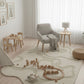 Children's playroom with a rug, toys, and furniture.