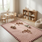 Children's playroom with a pink rug, wooden furniture, and toys.