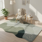 Living room with a green and gray rug, wooden chair, and small table.