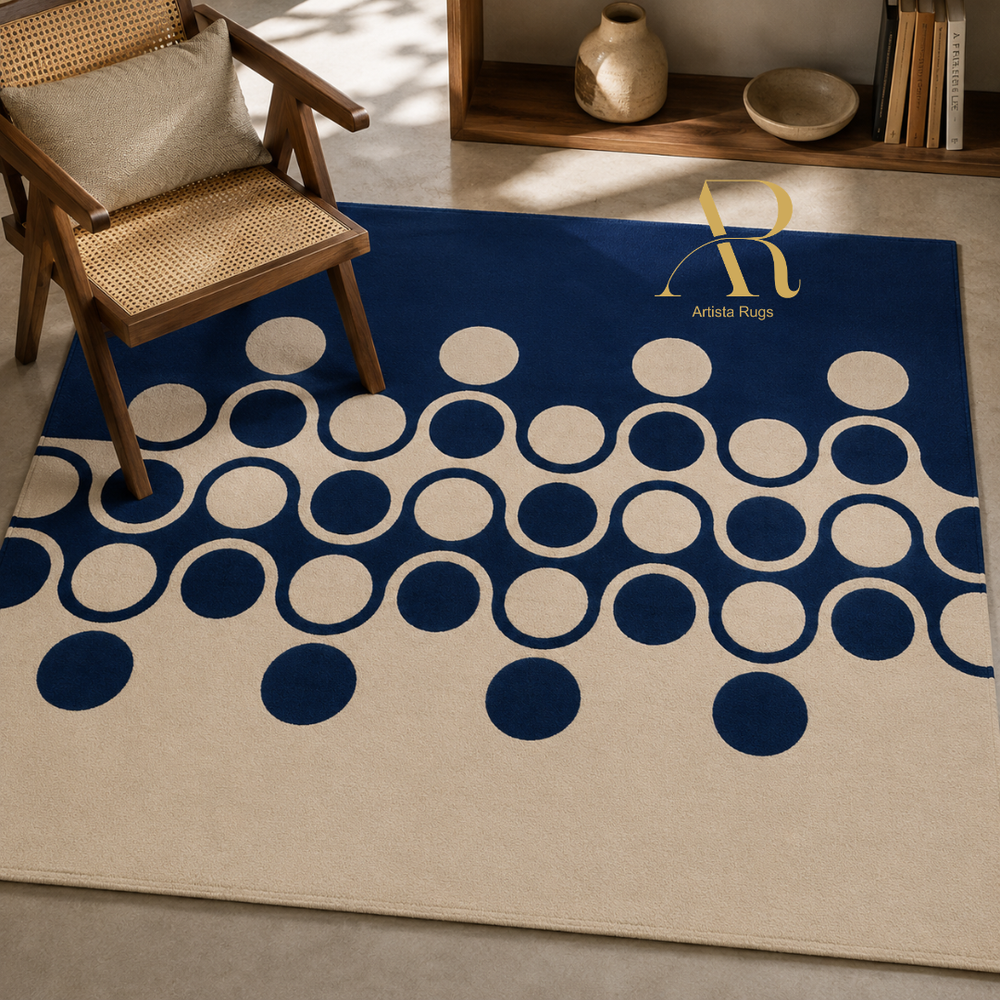 A rectangular area rug with a cream and navy blue geometric pattern of interlocking circles, styled in a modern living room setting next to a wooden armchair.
