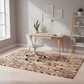 Modern home office with a wooden desk, chair, and patterned rug.