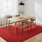 Dining room with wooden table and chairs on a red patterned rug.