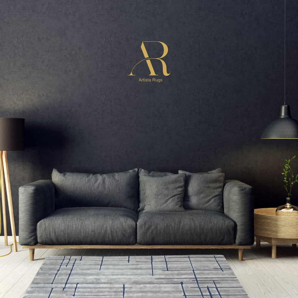 A modern hand-tufted rug with a grey base and blue lines, placed on a living room floor