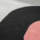 Close-up of a black and pink circular pattern on fabric.
