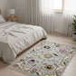 Floral patterned rug in a bedroom with a bed and lamp.