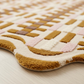 Close-up of a patterned rug with brown, pink, and beige colors on a light wooden floor.