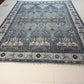 Decorative blue and beige rug on a light wooden floor