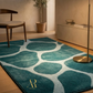 Teal area rug with circular patterns in a room with a chair and decorative items.