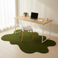 Modern home office with a desk, chair, and laptop on a green rug.