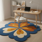 Colorful floral rug on a wooden floor with a desk and chair in the background.
