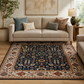 Living room with a patterned rug, beige sofa, and decorative pillows.